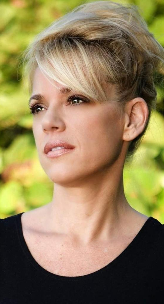 A woman with short blonde hair wearing black.